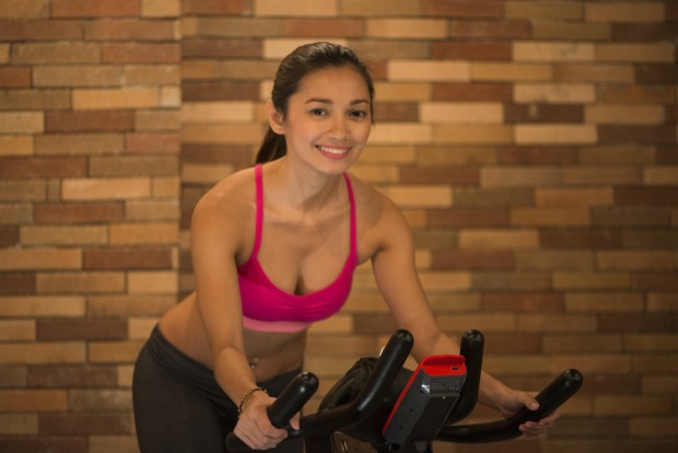 Saddle Row cycling instructor Carla Paredes demonstrates proper form on the bike.